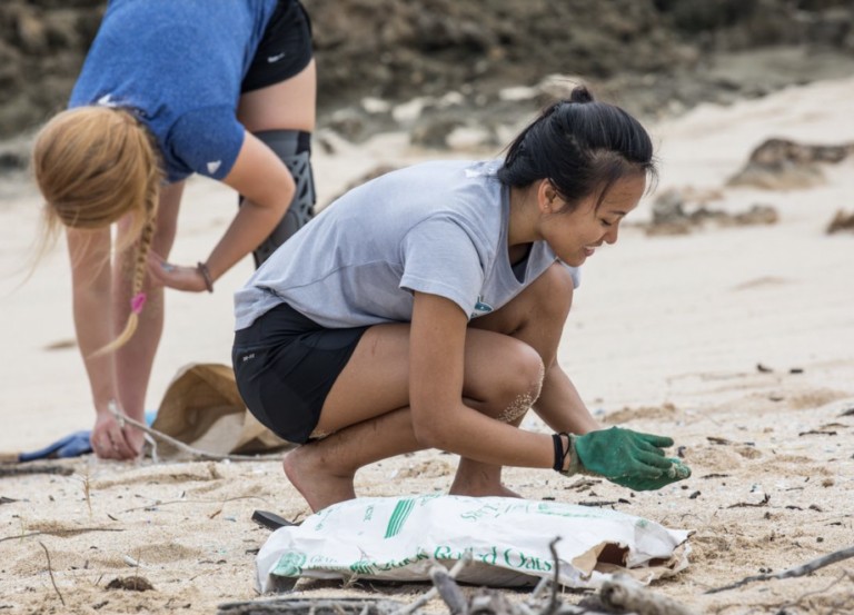 girls volunteer at a beach cleanup in Hawaiʻi